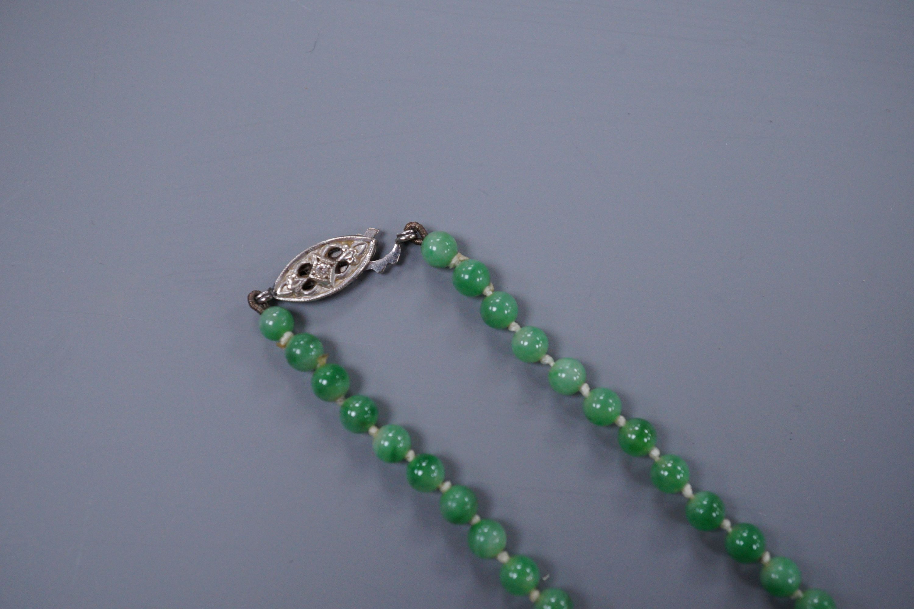 A graduated jade bead necklace with diamond set clasp stamped 9ct, 50cm